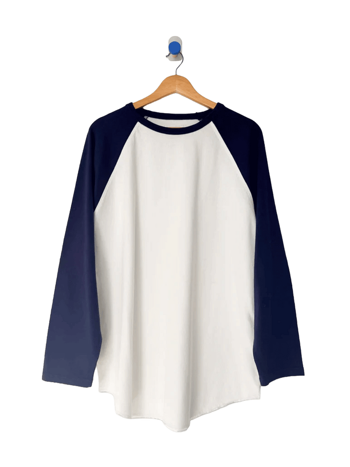 Le Bon Shoppe Raglan Tee in white with midnight navy sleeves on a wooden hanger | Twentyseven Toronto