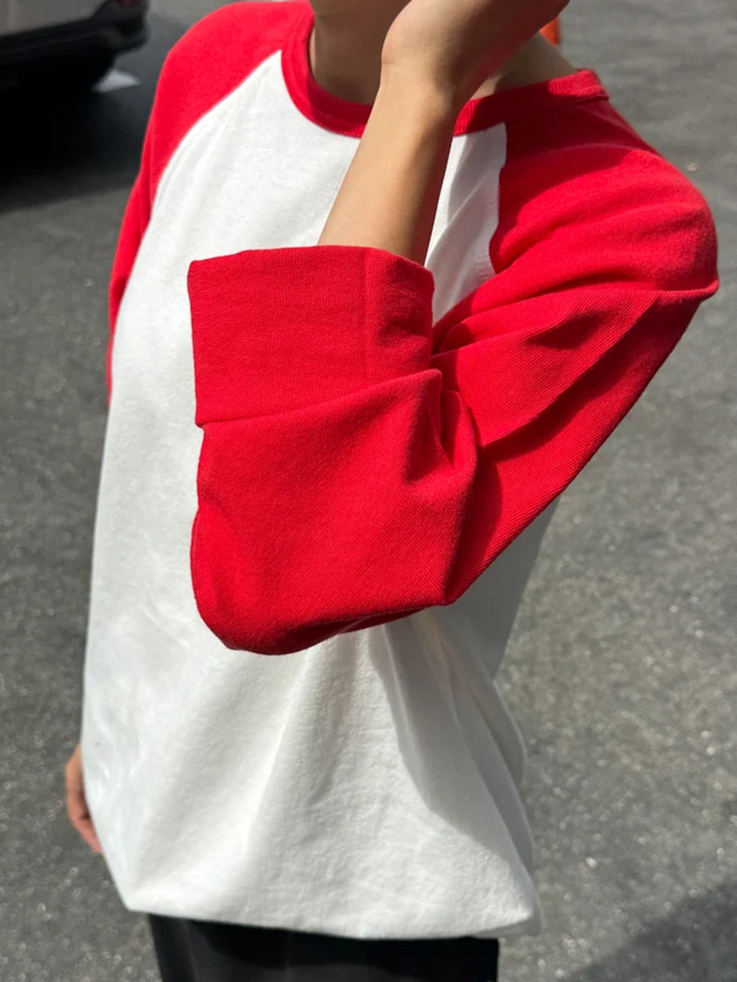 Close-up of the Le Bon Shoppe Raglan Tee showing the white body and tomato red raglan sleeve | Twentyseven Toronto