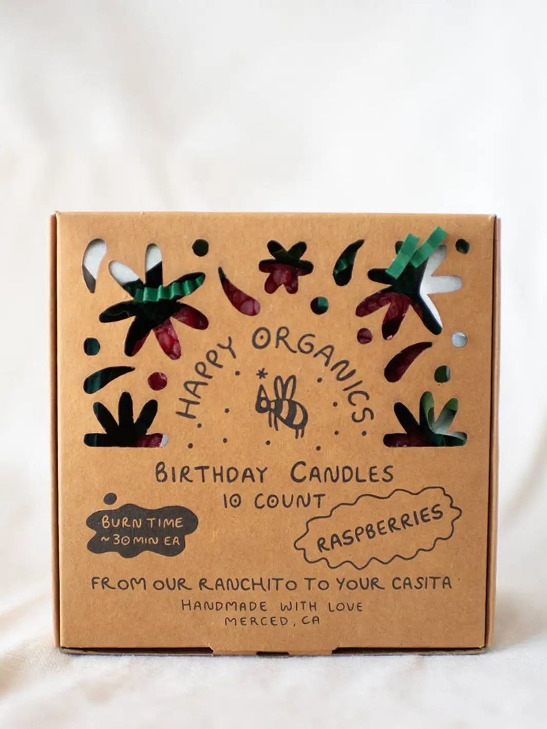 Box of Happy Organics raspberry birthday candles with decorative elements on a white background | Twentyseven Toronto