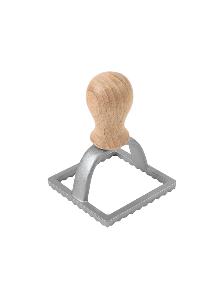 Metal ravioli stamp with wooden handle from Burstenhaus Redecker on a transparent background | Twentyseven Toronto