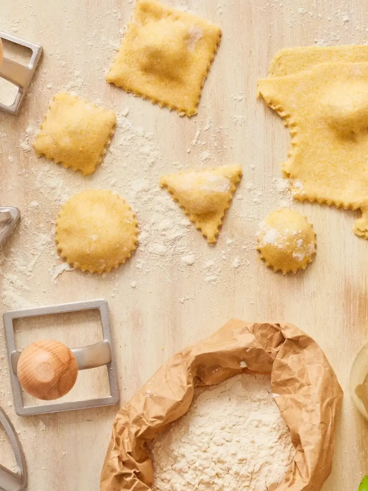 Uncooked ravioli on a floured surface with a Burstenhaus Redecker ravioli stamps | Twentyseven Toronto