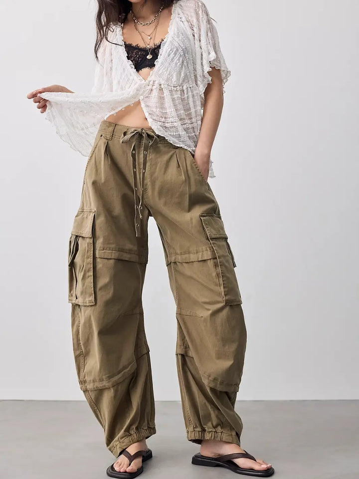 Front view of a model wearing Free People We the Free Reef Curved Twill Cargo Pants in Aloe styled with a white lace blouse and sandals | Twentyseven