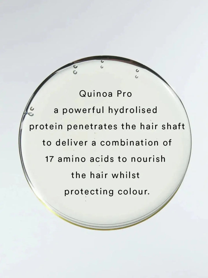 Black text layered over a large, clear droplet explains how Quinoa Pro protein in Hair by Sam McKnight Rich Cleanse Nourishing Shampoo helps protect color and nourish the hair shaft | Twentyseven Toronto