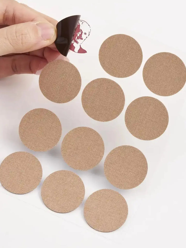 Brown circular Roihi Tsuboko Pain Relief Patches on a white background with a hand holding one patch | Twentyseven Toronto