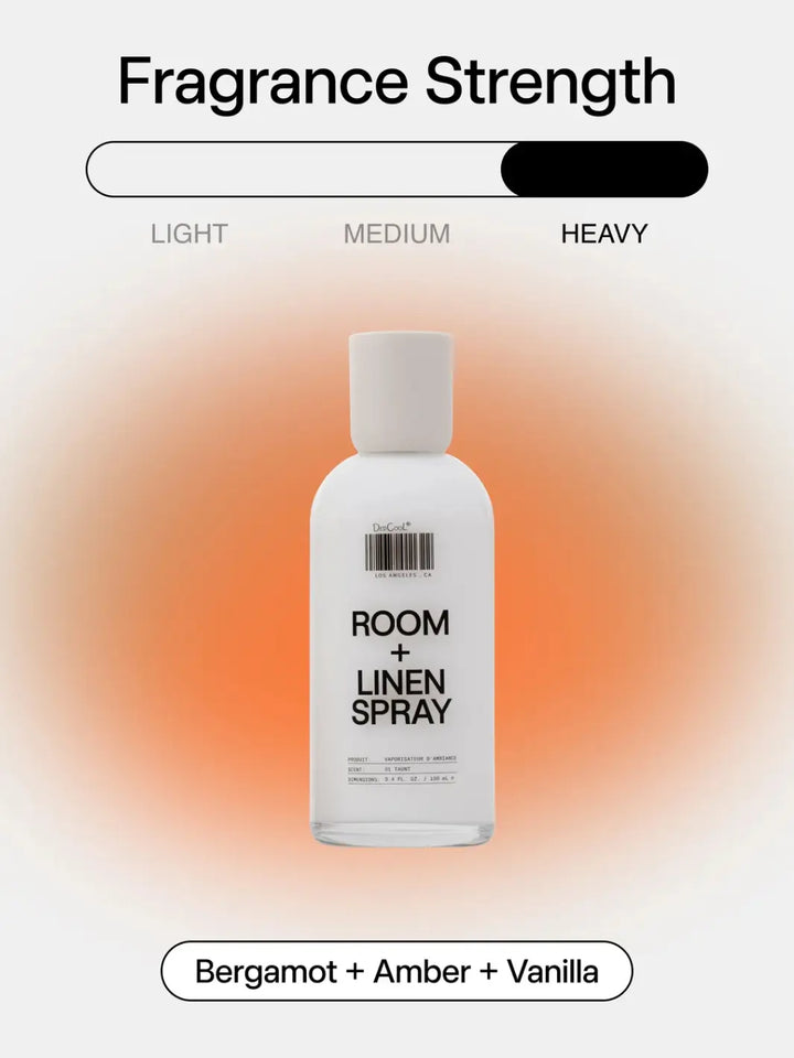 A 100ml bottle of Dedcool Room + Linen Spray 01 "Taunt" on a soft orange gradient background beneath a "Heavy" fragrance strength graphic and above a label reading "Bergamot + Amber + Vanilla" | Twentyseven Toronto