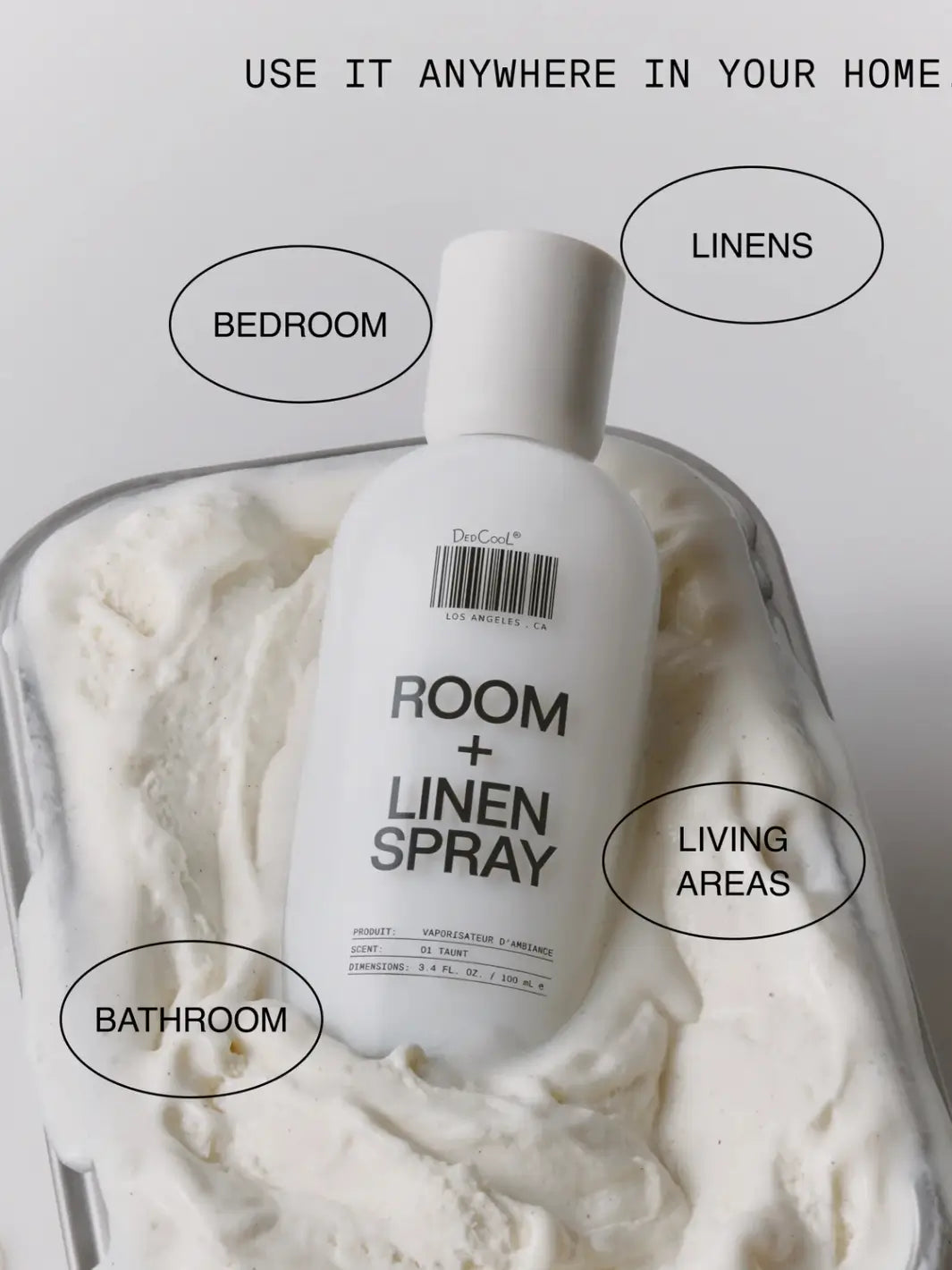 A 100ml bottle of Dedcool Room + Linen Spray 01 "Taunt" resting in a tray of thick white cream surrounded by circular text bubbles indicating home uses like bathroom, bedroom, linens, and living areas | Twentyseven Toronto