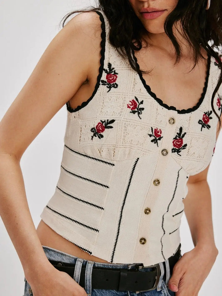 A detailed close-up focuses on the delicate pointelle knit texture, button-down placket, and red floral embroidery on the bodice of the Free People Rose Bud Knit Top - Ivory Combo | Twentyseven Toronto