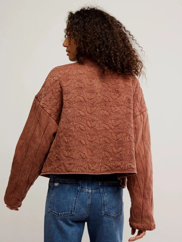 A view from behind captures the intricate all-over rose and leaf embroidery covering the back panel of the Free People Rose Zip-Up Sweatshirt - Cinnamon Stick | Twentyseven Toronto