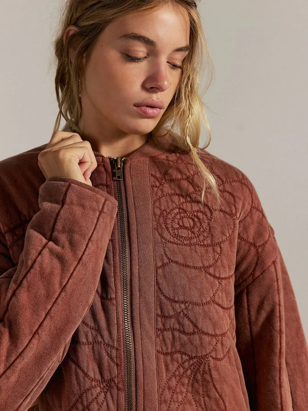 A detailed front close-up emphasizes the textured rose embroidery on the chest and the sturdy zipper construction of the Free People Rose Zip-Up Sweatshirt - Cinnamon Stick | Twentyseven Toronto