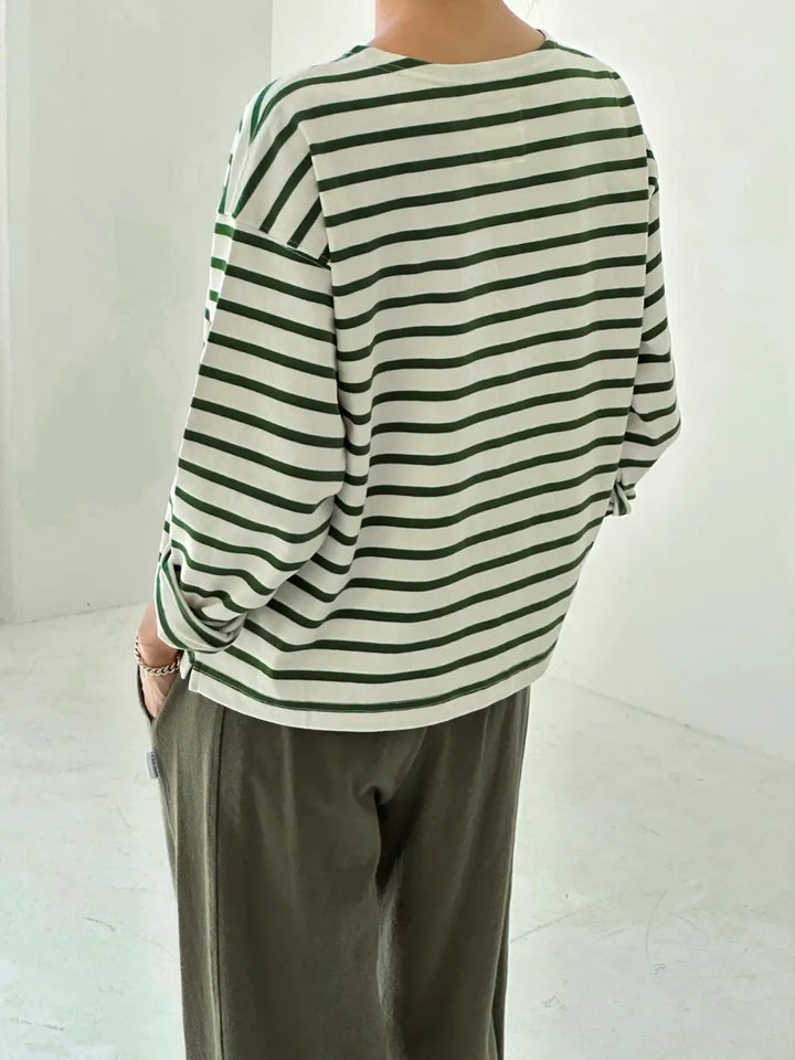 Back view of person wearing a green and white striped 'Sailor Top' long sleeve shirt in 'Pine Stripe' with green pants from Le Bon Shoppe on a white background | Twentyseven Toronto