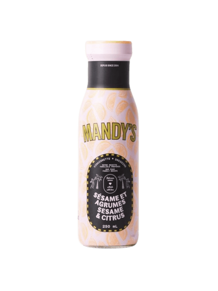 A 250 mL glass bottle of Mandy's Sesame Citrus dressing features a light pink, citrus-printed wrap label with a black central crest reading "Sésame et Agrumes / Sesame & Citrus" | Twentyseven Toronto