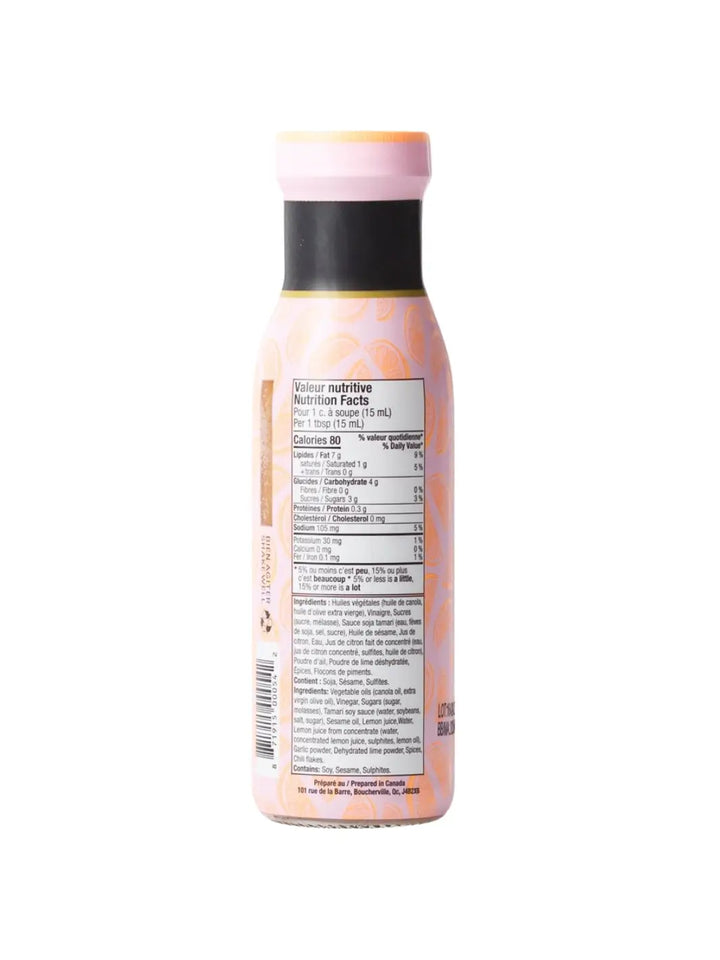 The back of a Mandy's Sesame Citrus dressing bottle displays its nutrition facts panel and ingredient list over a light pink, citrus-patterned background | Twentyseven Toronto