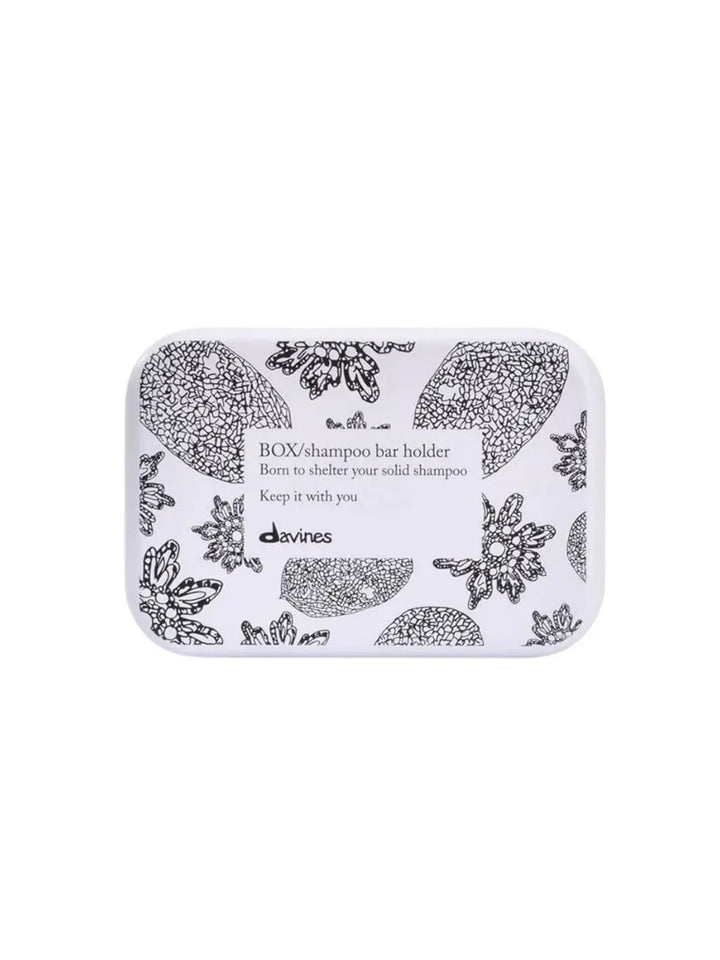 A rectangular white Davines Shampoo Bar Travel Case features a black floral and botanical pattern with a central label text against a white background | Twentyseven Toronto