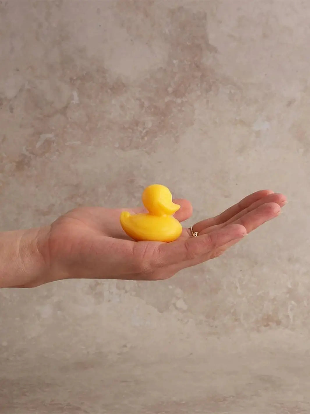 Yellow Sheep's Milk Soap in 'Duckling' from Burstenhaus Redecker held in hand on a beige background | Twentyseven Toronto