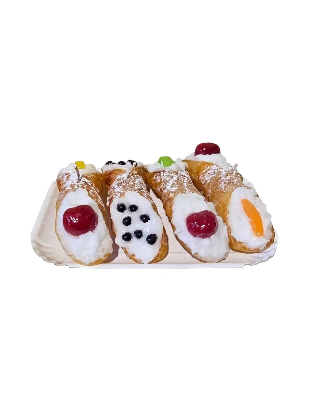 4 Sicilian Cannolo Candles with cream, berries, and colourful decorations on a white plate from Cereria Introna against a transparent background | Twentyseven Toronto