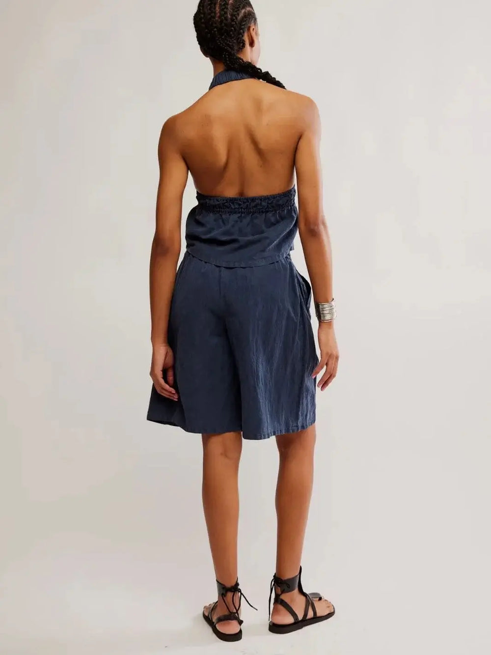 A view from behind highlights the completely open-back design of the halter top and the comfortable elastic waistband of the Free People Sidra Set - India Ink shorts | Twentyseven Toronto