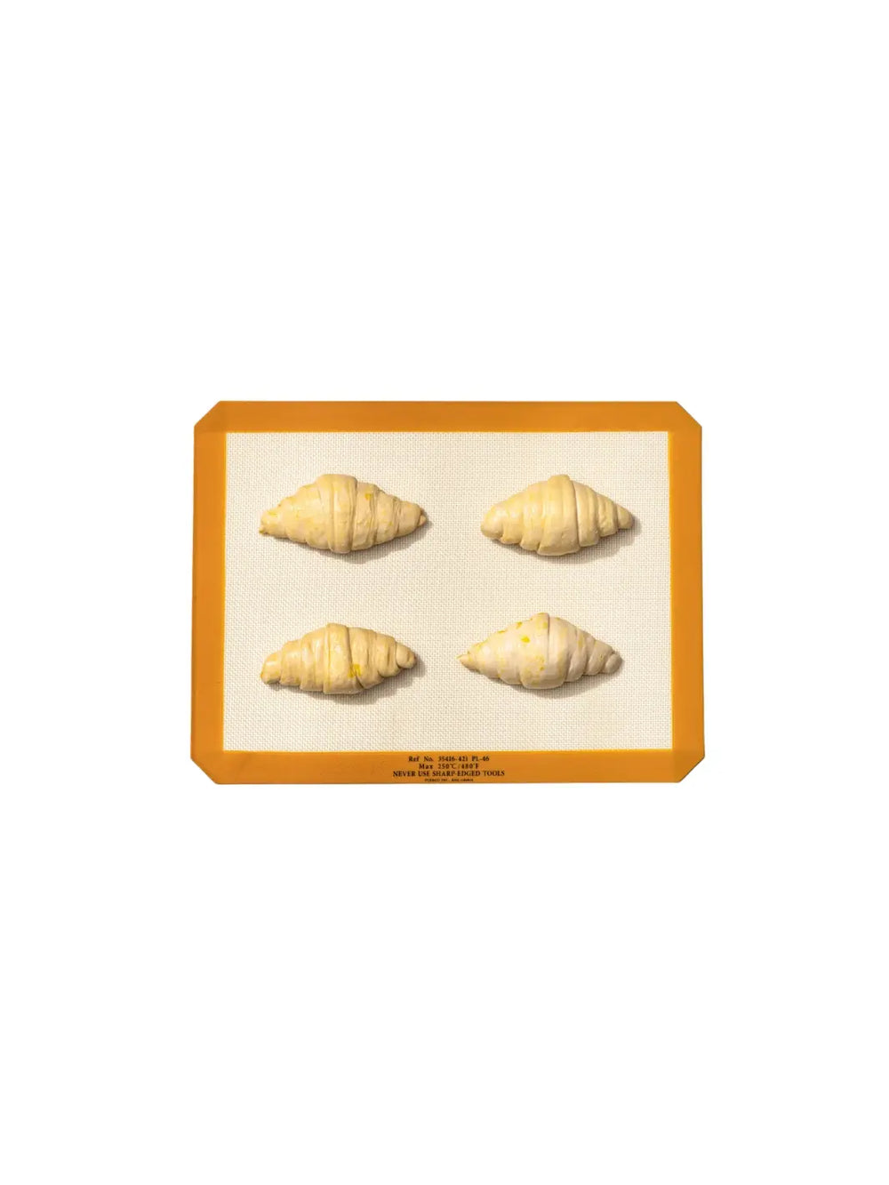 Four croissants are arranged on an orange-bordered Silicone Placemat from Puebco, demonstrating its dual-purpose functionality as both a dining accessory and a baking liner | Twentyseven Toronto