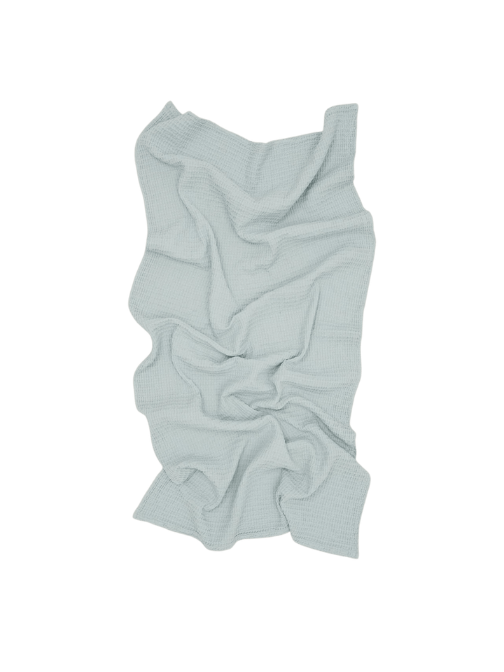 A soft, light blue towel is artfully crumpled showcasing the unique texture of the Simple Waffle Towel - Sky from Hawkins New York against a transparent background | Twentyseven Toronto