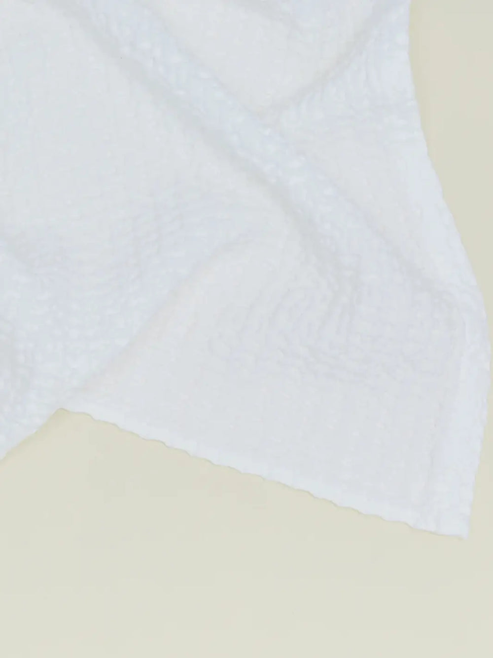 A close-up view highlights the intricate woven grid texture of a white towel from the Simple Waffle Towel - White from Hawkins New York collection | Twentyseven Toronto