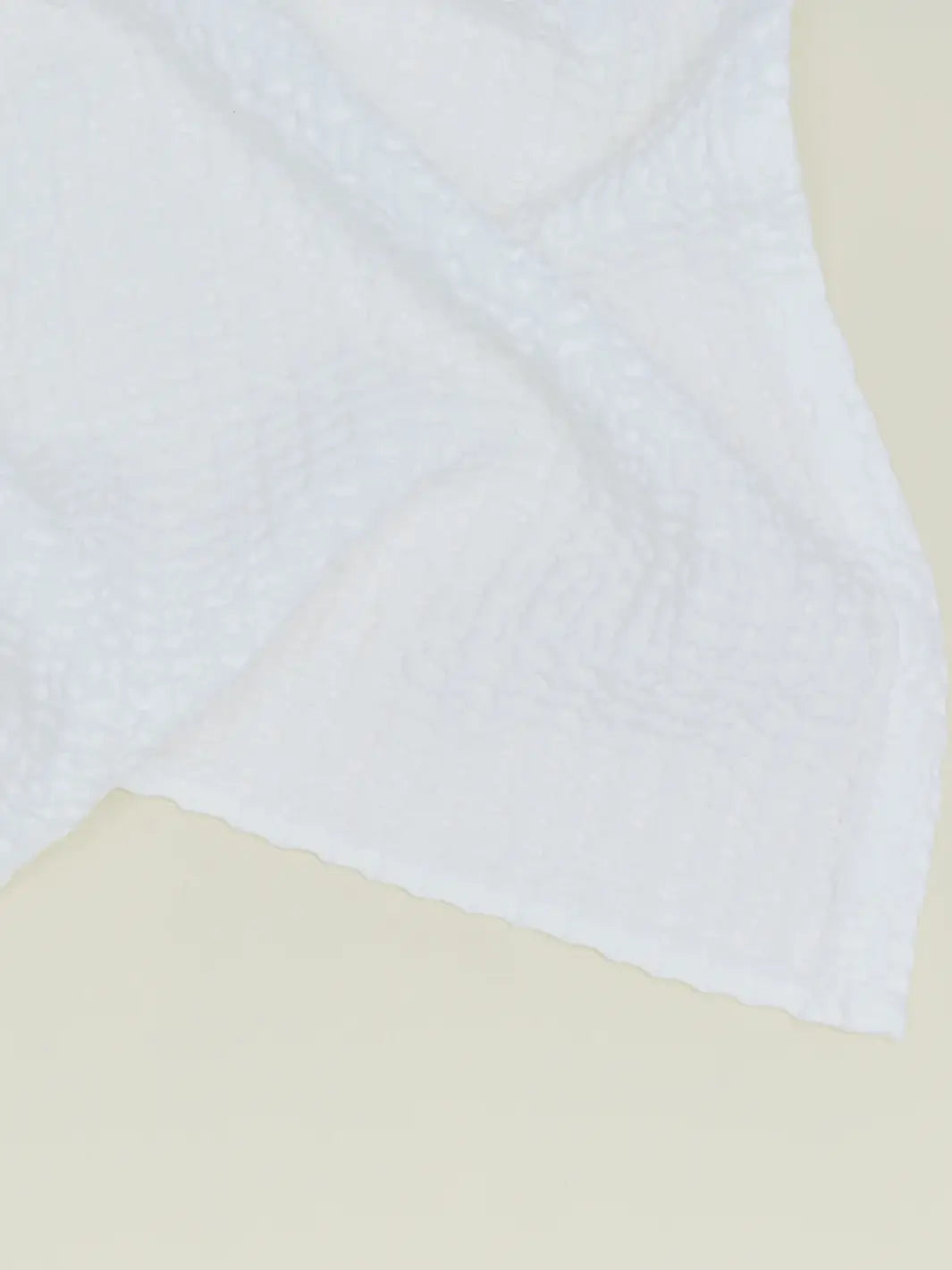 A close-up view highlights the intricate woven grid texture of a white towel from the Simple Waffle Towel - White from Hawkins New York collection | Twentyseven Toronto