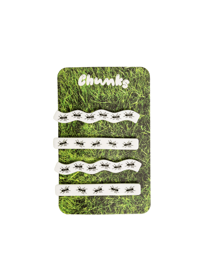 Four white hair clips decorated with a black ant print from the CHUNKS Slides in Ants Barrette set are displayed on a grass-printed backing card | Twentyseven Toronto