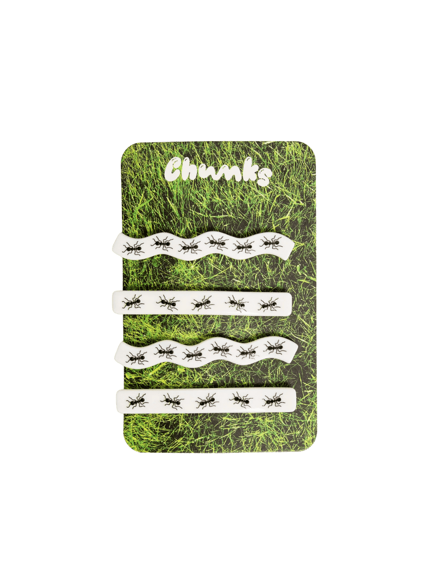Four white hair clips decorated with a black ant print from the CHUNKS Slides in Ants Barrette set are displayed on a grass-printed backing card | Twentyseven Toronto