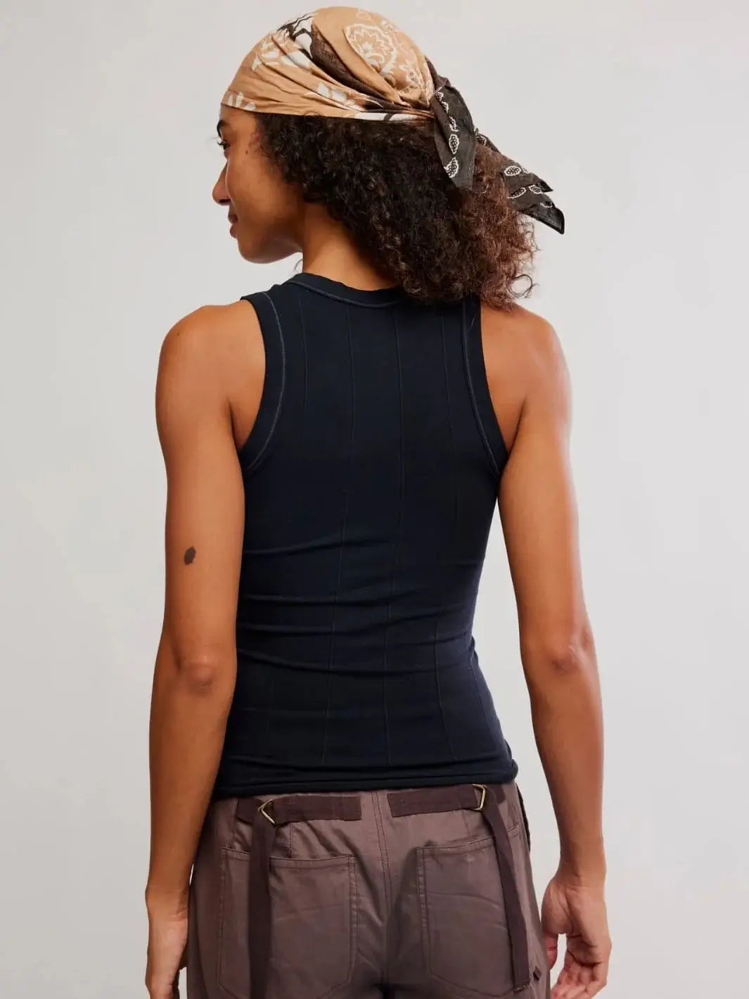 A direct rear view focuses on the racerback-style armholes and vertical ribbed paneling of the Free People So Soft Seamless Modal Tank in Black | Twentyseven Toronto