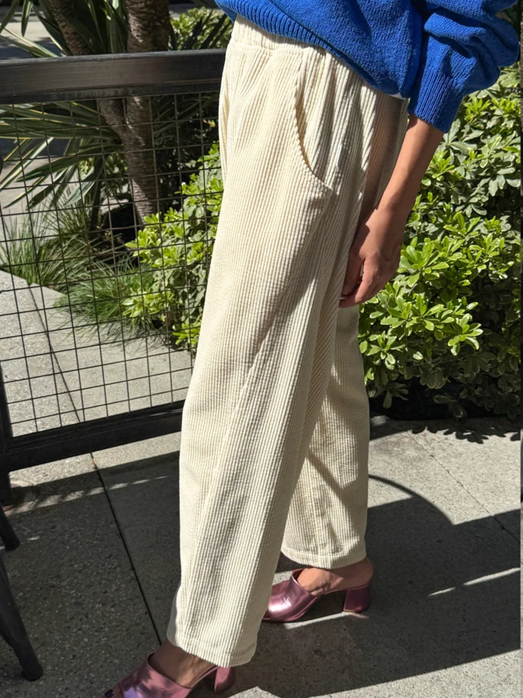 Le Bon Shoppe Soft Corduroy Arc Pants in Ecru worn outdoors, side view showing curved leg and pocket | Twentyseven Toronto