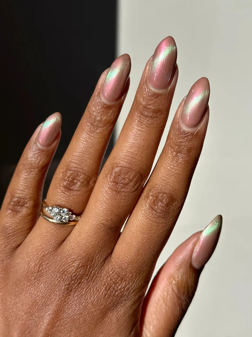 Hand with long pink and light green gradient nails using 'Something Else' magnetic nail polish by Death Valley Nails wearing a diamond ring on a neutral background | Twentyseven Toronto