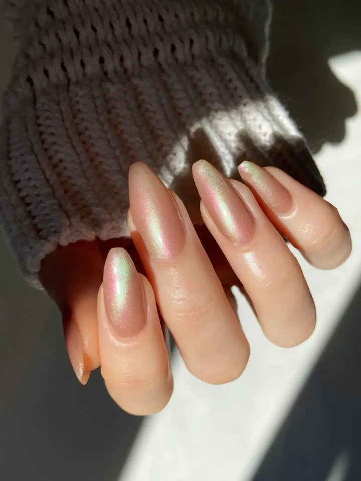 Close up of hand with long pink and light green gradient nails using 'Something Else' magnetic nail polish by Death Valley Nail wearing a grey textured sleeve | Twentyseven Toronto