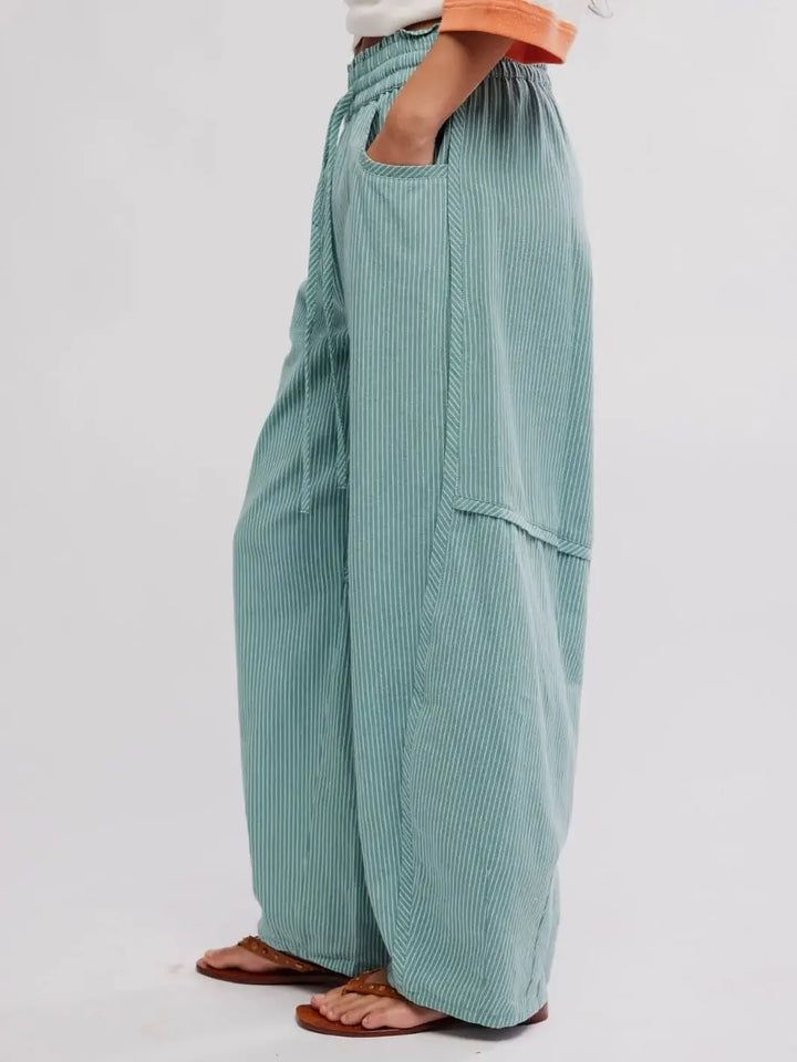 A side profile view displays the relaxed silhouette and fine white vertical pinstripes of the Free People Something Good Pant in Blue Trellis Combo | Twentyseven Toronto
