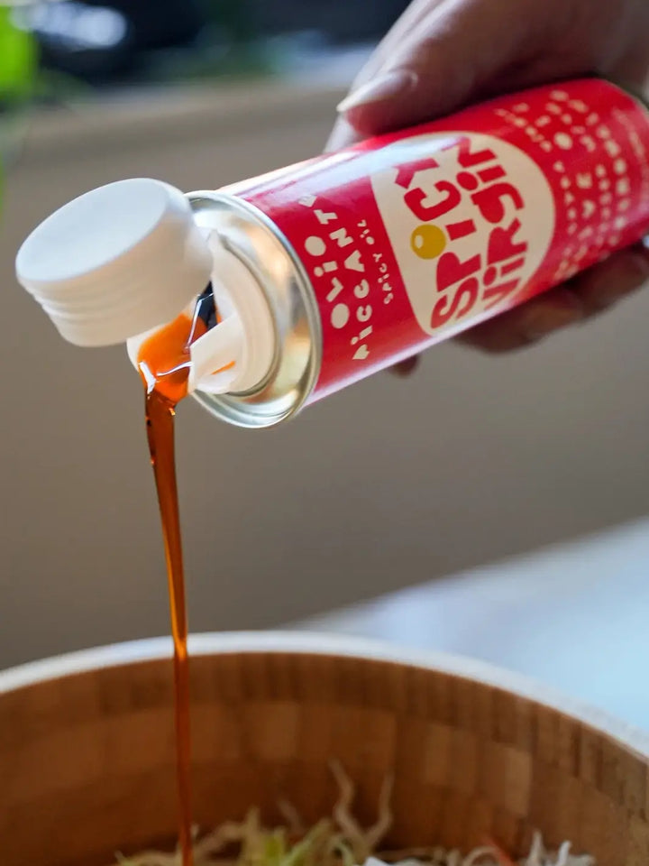 Red can of Spicy Virgin Olive Oil from Casa Virgin being poured into a bowl | Twentyseven Toronto
