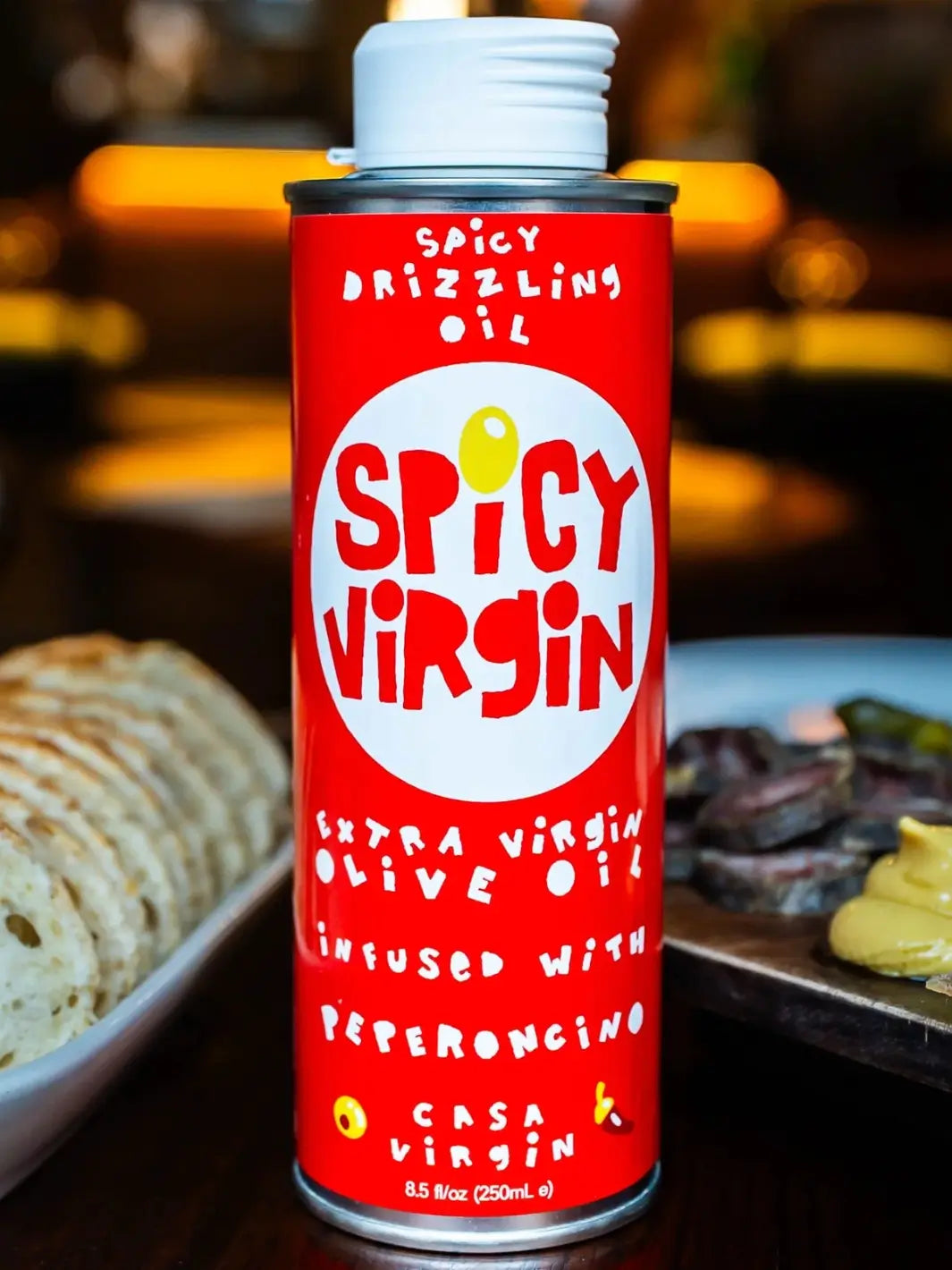 Red can of 'Spicy Virgin' olive oil from Casa Virgin with a blurred background | Twentyseven Toronto