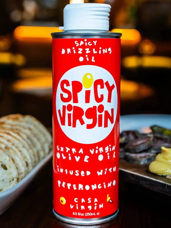 Red can of 'Spicy Virgin' olive oil from Casa Virgin with a blurred background | Twentyseven Toronto