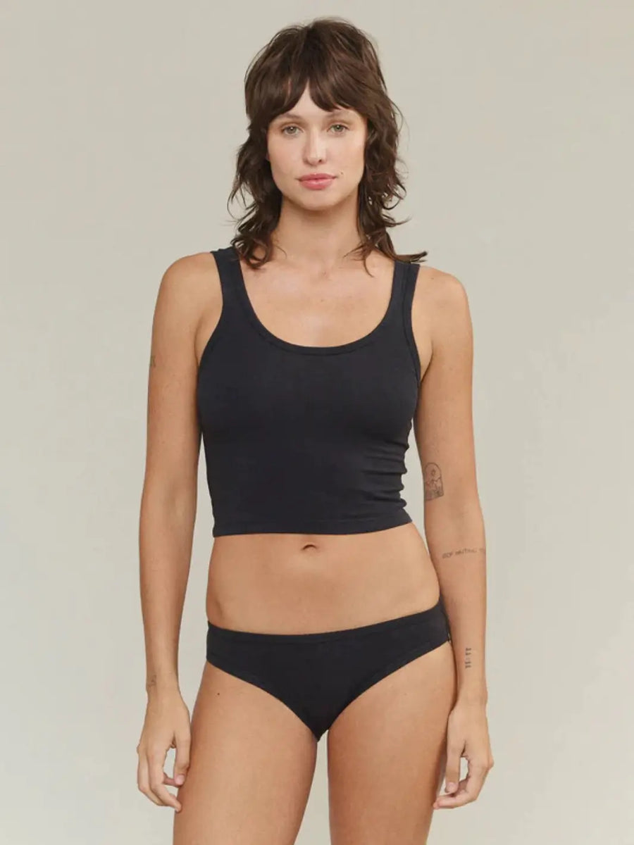 A model poses from the front wearing a fitted, scoop-neck Jungmaven Sporty Tank - Black paired with matching black underwear | Twentyseven Toronto