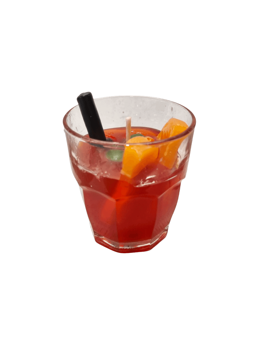 Clear glass with a red cocktail, orange slice, and black straw wax candle from Cereria Introna on a transparent background | Twentyseven Toronto