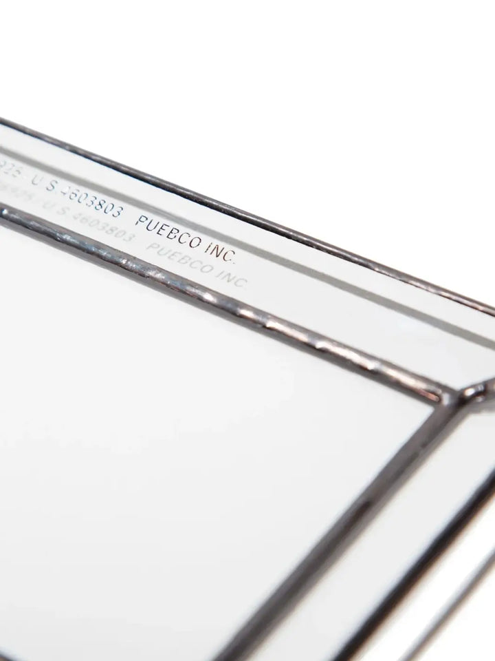 A close-up, detailed view of the corner of a Stained Glass Tray from Puebco, highlighting the dark soldered edges and the clean, stamped brand text along the inner rim | Twentyseven Toronto