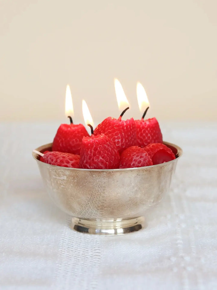 Bowl with lit strawberry beeswax candles on a white surface | Twentyseven Toronto