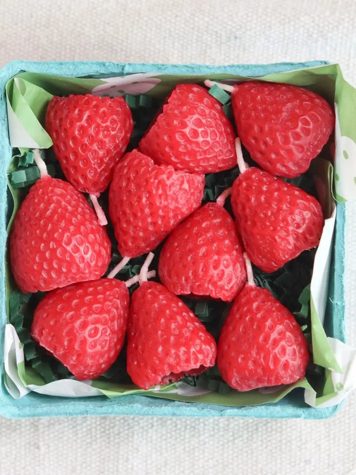 Red strawberry-shaped beeswax candles from Happy Organics in a box on a white background | Twentyseven Toronto
