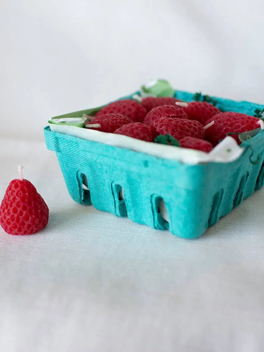 Box of strawberry shaped beeswax candles from Happy Organics in blue carton on a white background | Twentyseven Toronto
