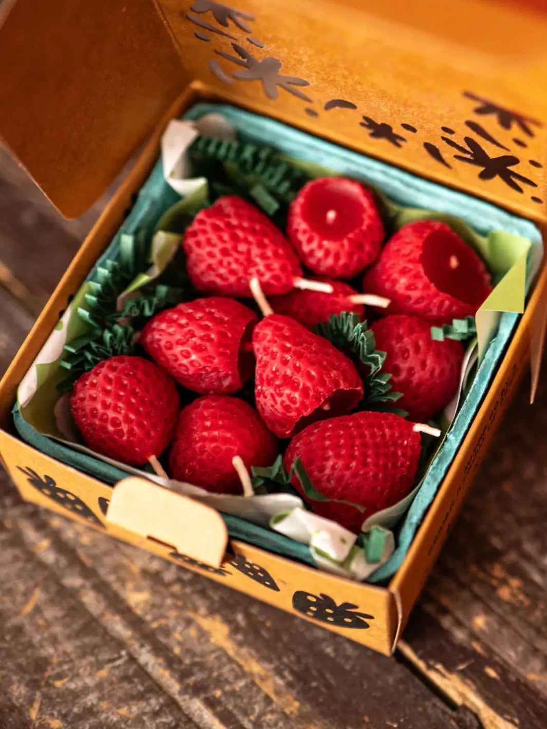Box of strawberry shaped candles from Happy Organics in brown packaging on a wooden background | Twentyseven Toronto