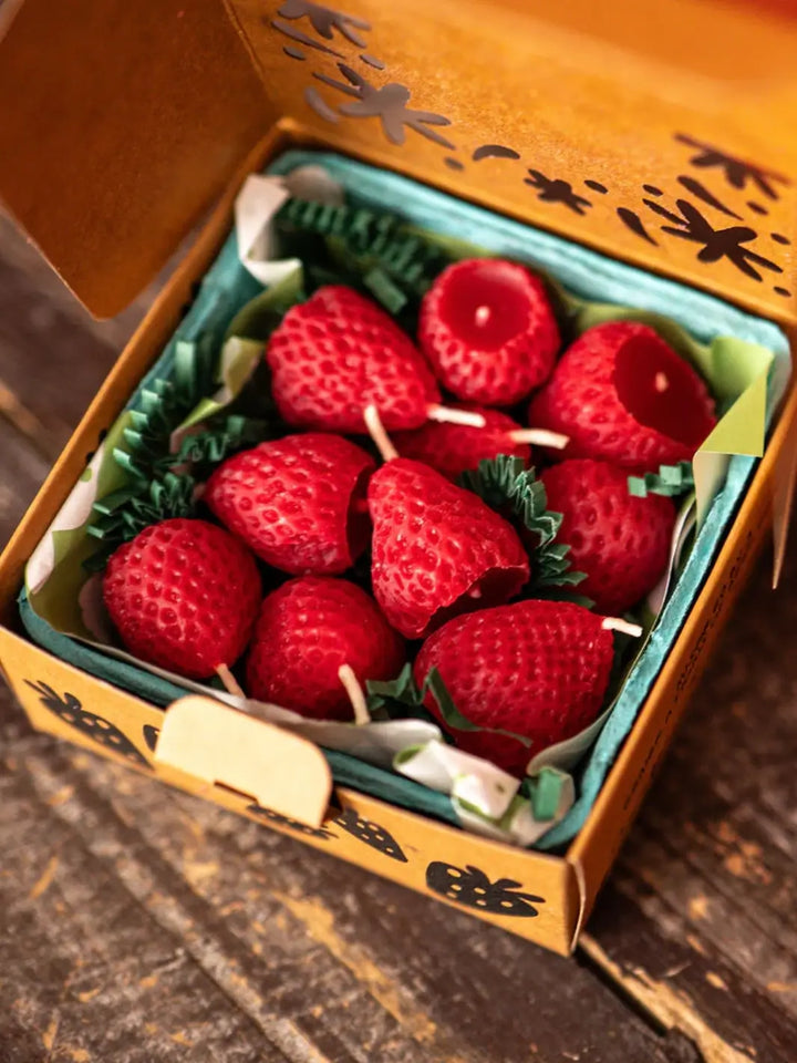 Box of strawberry shaped candles from Happy Organics in brown packaging on a wooden background | Twentyseven Toronto
