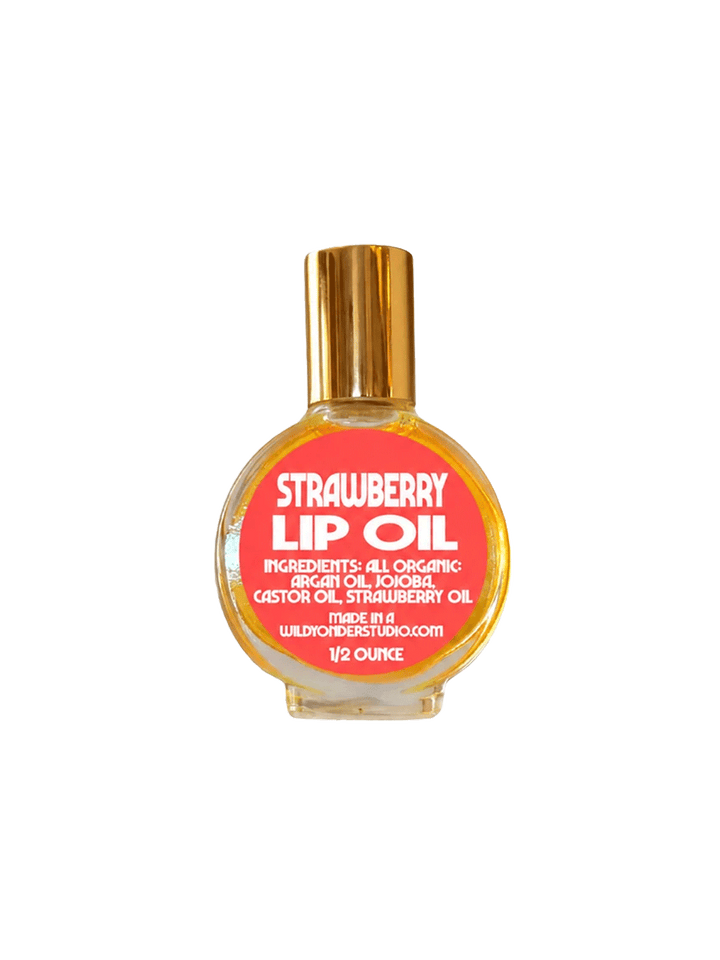 Wild Yonder Studio Strawberry Lip Oil in a glass bottle with a coral pink label and gold cap | Twentyseven Toronto