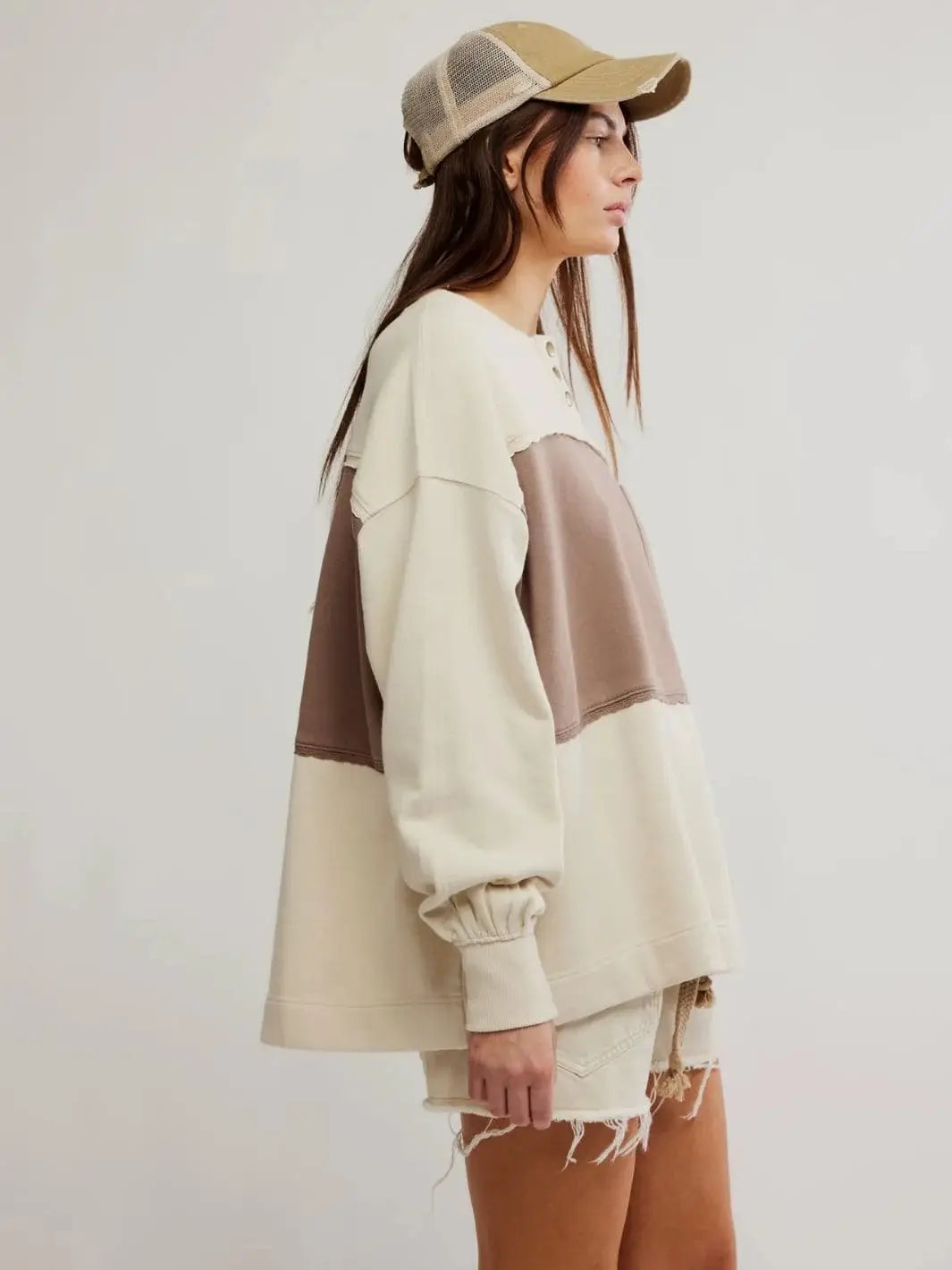 A side profile view displays the longline, dropped-shoulder silhouette of the Free People Strawberry Sweatshirt - Summer Sand Combo | Twentyseven Toronto