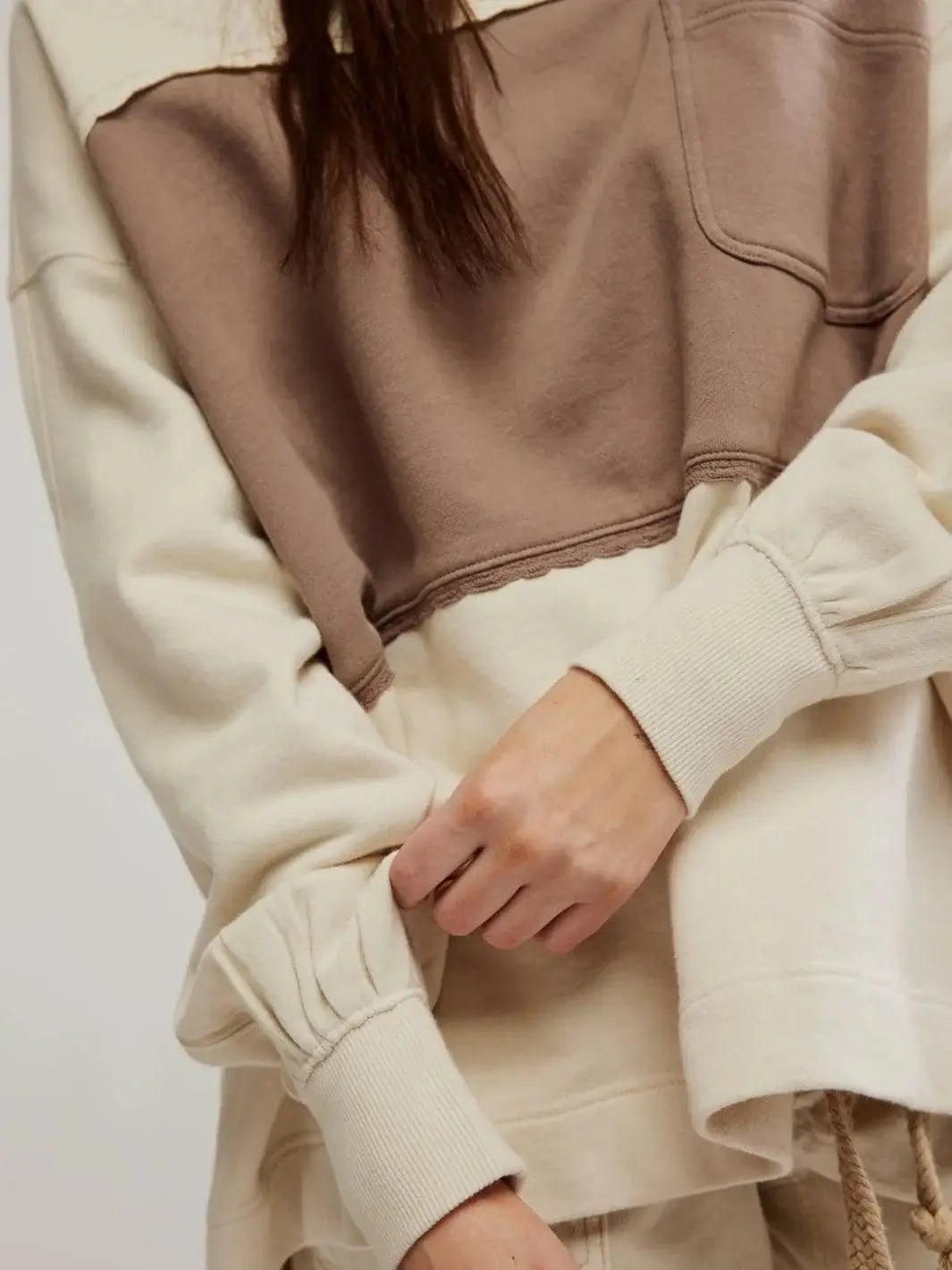A detailed close-up highlights the ribbed cuffs, gathered sleeve fabric, and color-blocked design of the Free People Strawberry Sweatshirt - Summer Sand Combo | Twentyseven Toronto