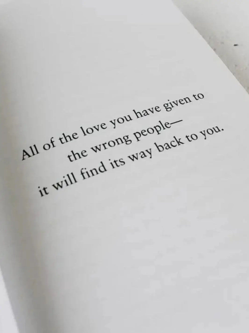 A close-up shot of an open page from The Strength In Our Scars by Bianca Sparacino features a short printed quote about love finding its way back to you | Twentyseven Toronto
