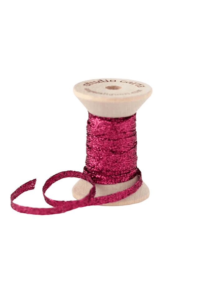 Studio Carta Metallic Braided Ribbon in Berry wrapped around a wooden spool with ribbon unfurled | Twentyseven Toronto