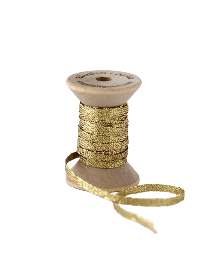 Studio Carta Metallic Braided Ribbon in Gold wrapped around a wooden spool with ribbon unfurled | Twentyseven Toronto