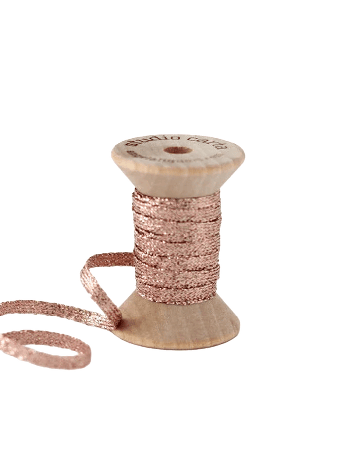 Studio Carta Metallic Braided Ribbon in Rose Gold wrapped around a wooden spool with ribbon unfurled | Twentyseven Toronto