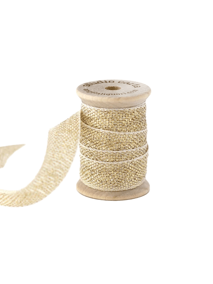 Studio Carta Metallic Loose Weave Ribbon in Natural//Gold wrapped around a wooden spool with ribbon unfurled | Twentyseven Toronto